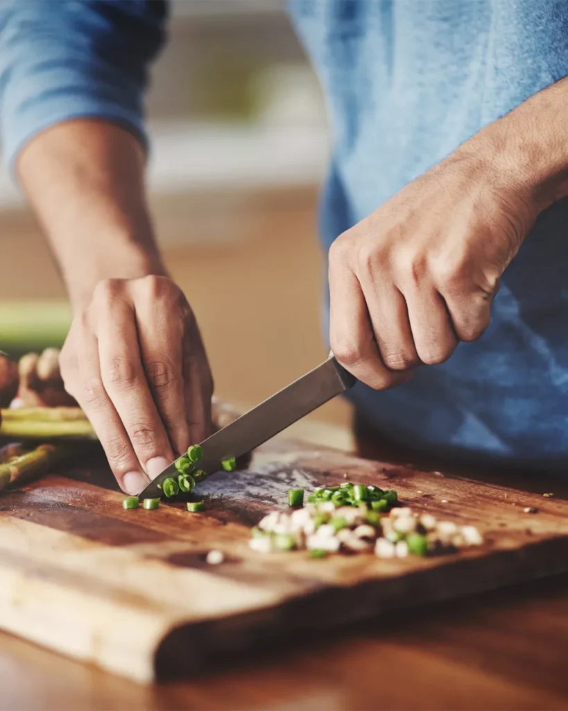 Close-up of man chopping vegetables.
