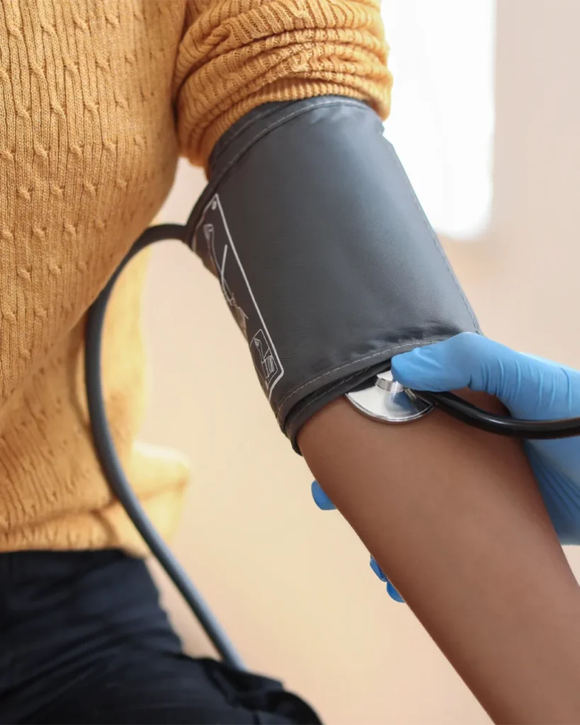 Female patient receiving a blood pressure check from a functional wellness provider.
