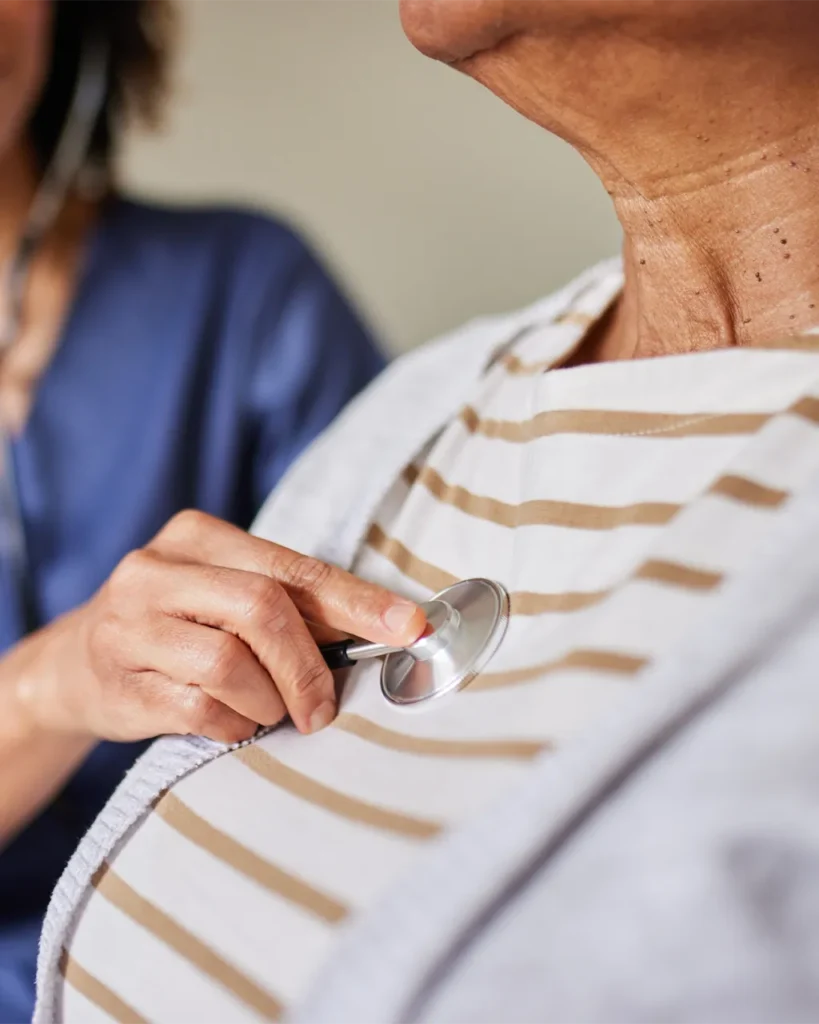 Functional medicine provider examining a patient with a stethoscope during their first visit.